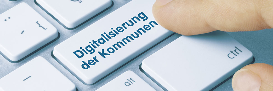 Symbolbild Modellkommunen - Person tippt mit Zeigefinger auf Computertaste mit der Aufschrift "Digitalisierung der Kommunen"